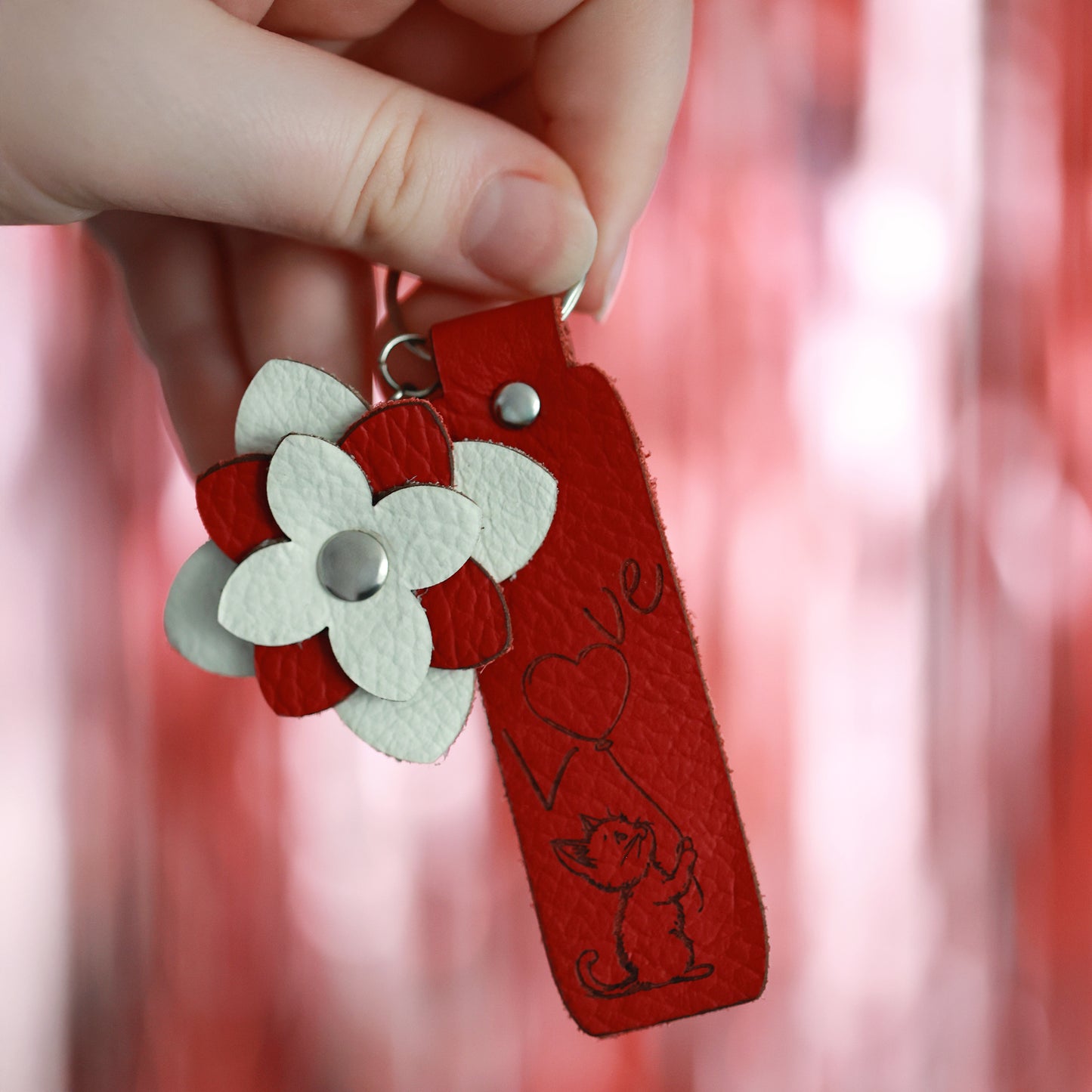 Handgefertigter Schlüsselanhänger mit weiß-roter Lederblume – Graviertes Motiv Katze und Love auf rotem Lederstreifen, Silberner Schlüsselring, Geschenkidee