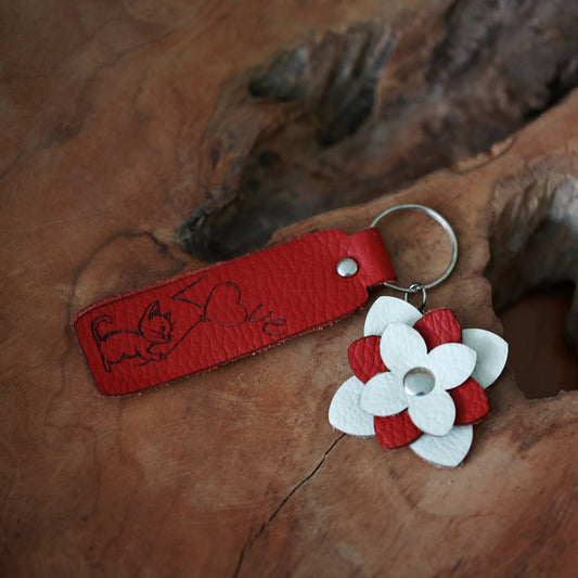 Handgefertigter Schlüsselanhänger mit weiß-roter Lederblume – Graviertes Motiv Katze und Love auf rotem Lederstreifen, Silberner Schlüsselring, Geschenkidee